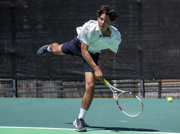 Jugador de tenis realizando un saque en una cancha de La Cristianía, Chapala
