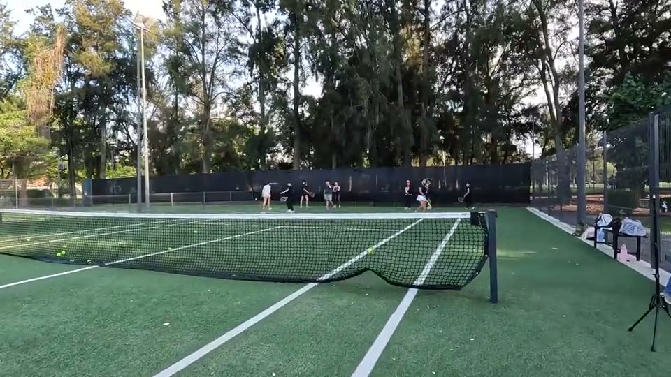Profesor y alumnos en una clase de tenis